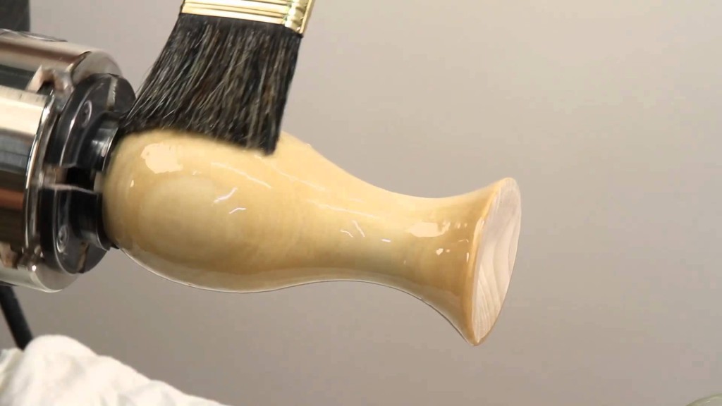 Applying sanding sealer with a bristle brush.
