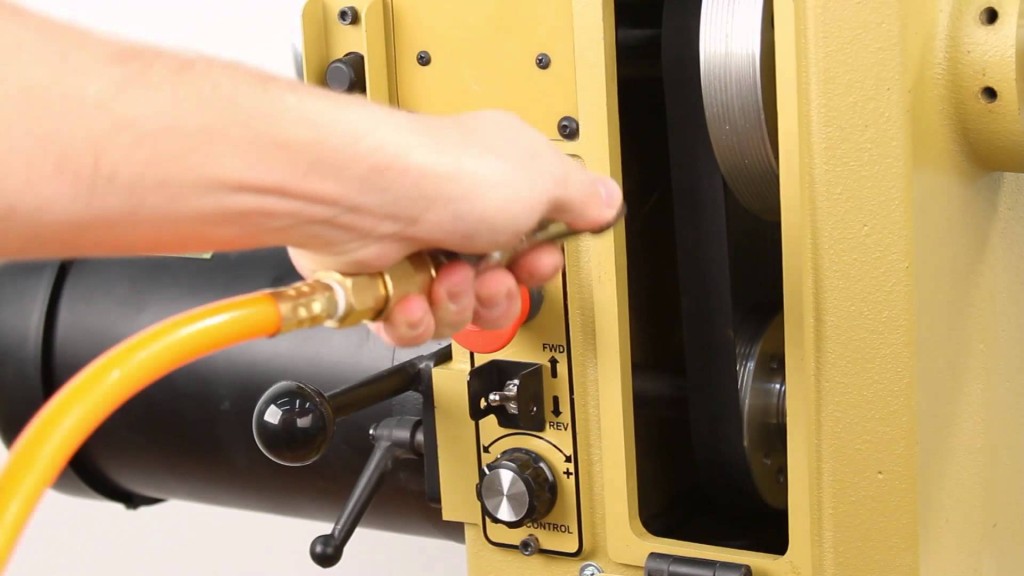 Cleaning lathe belts with compressed air.