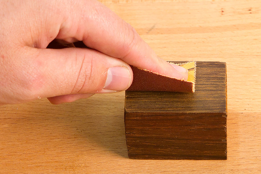 Hand sanding the surface of a blank.