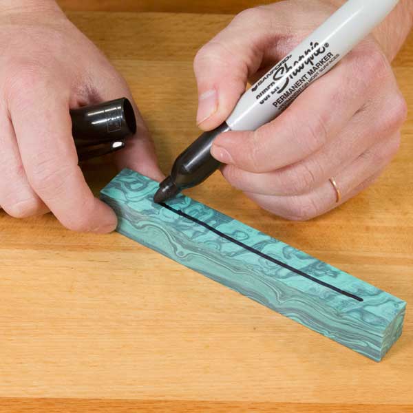 Drawing a line on the blank with a marker.