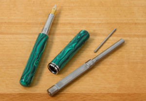 A closed end pen and mandrel laying on a table.