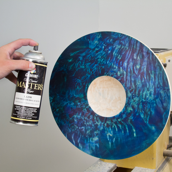 Using a spray can to apply a coat of lacquer.