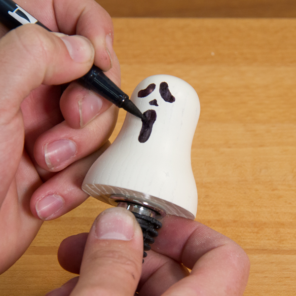 Drawing the ghost face with a marker.