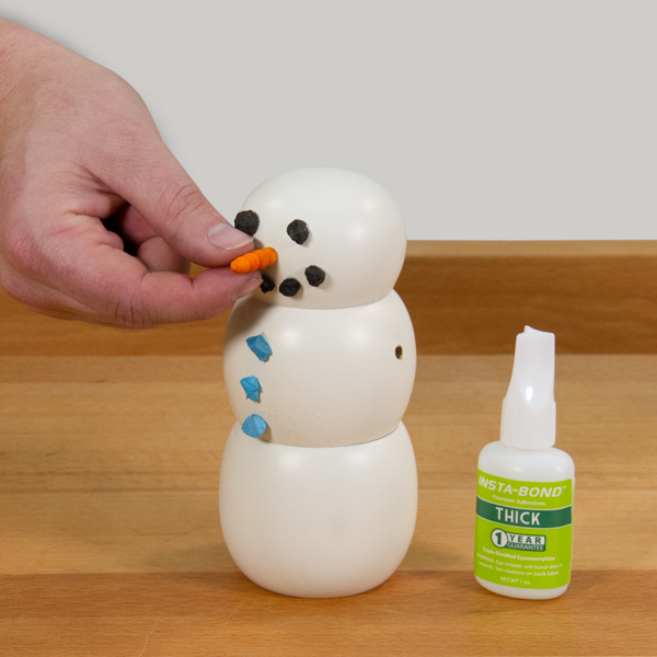 Gluing a nose on the snowman.