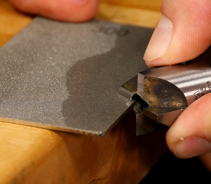Sharpening a barrel trimmer on a diamond hone.
