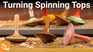 Group of spinning tops on a lathe bed.