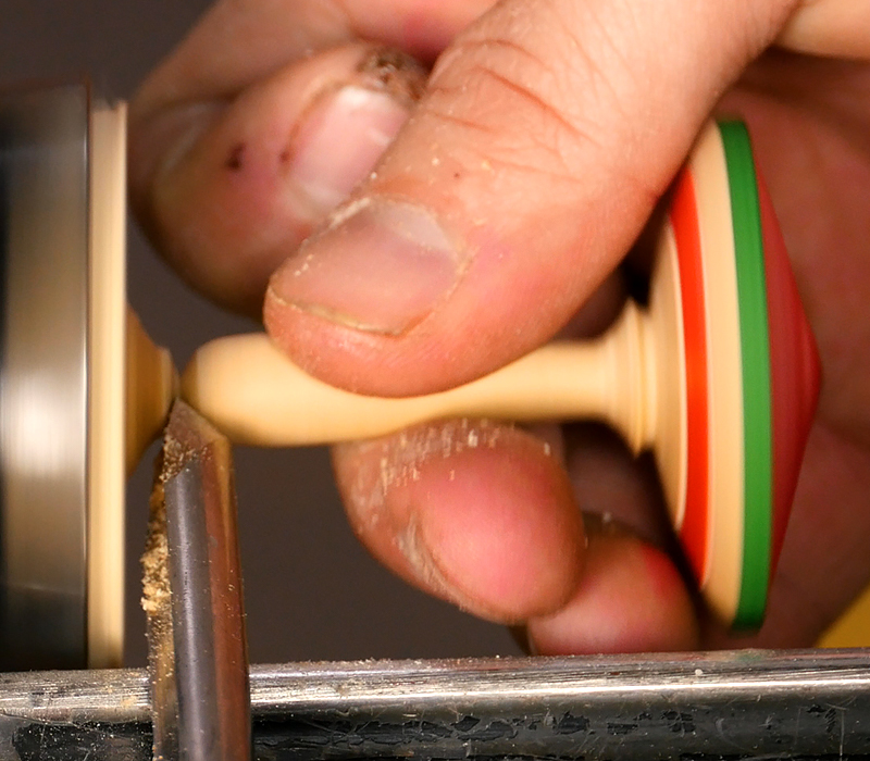 Parting off the handle with a spindle gouge.