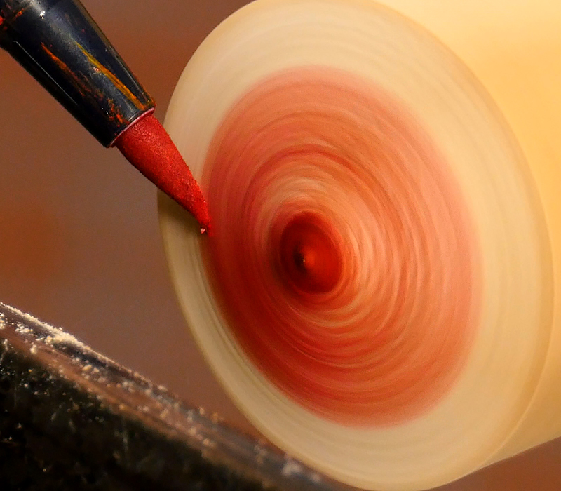 Adding red color with a Tombow marker with the lathe running.