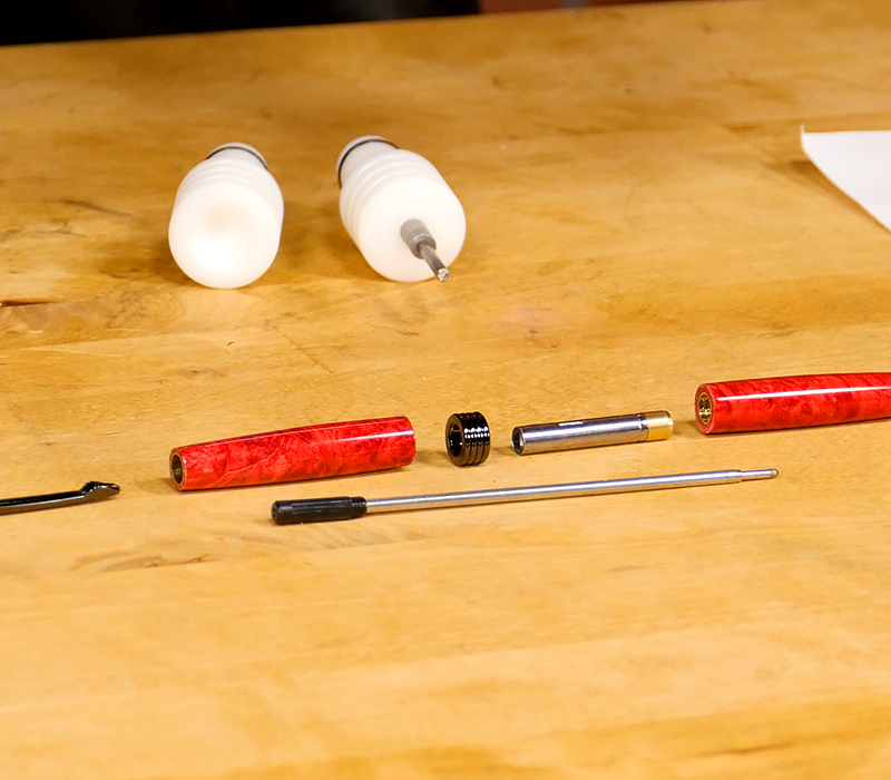 Pen parts and blanks laid on a table.