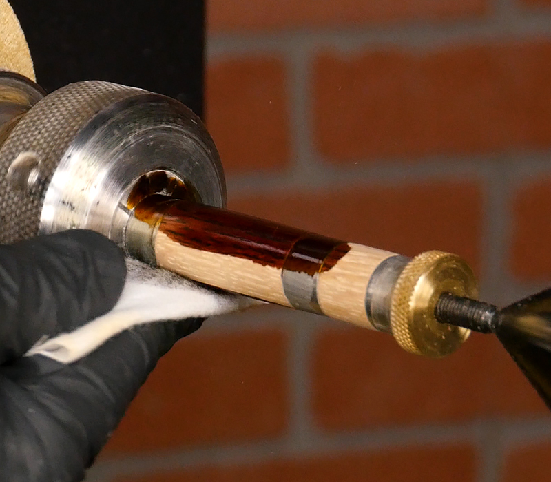 Applying brown wood dye with a cotton cloth.